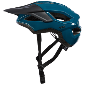 Der O'NEAL MATRIX Helm SOLID, perfekt für Mountainbike- und Trekkingtouren, besticht durch ein auffälliges blaues Design mit schwarzen und grauen Akzenten. Er verfügt über mehrere Belüftungsöffnungen, einen verstellbaren schwarzen Kinnriemen und ein abnehmbares Visier auf der Vorderseite. Der Markenname „O'NEAL“ ist prominent auf der Seite angebracht.