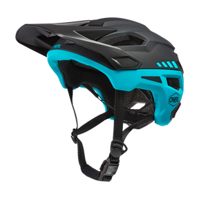 Der O'NEAL TRAILFINDER Helm SPLIT, ein schwarz-blaugrünes Wunderwerk von O'NEAL, verfügt über ein Visier, verstellbare Kinnriemen, reichlich Belüftungsöffnungen und ein schlankes, modernes Design, ideal für abenteuerlustige Fahrer.