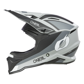 Der O'NEAL 1SRS Helm STREAM ist ein Integralhelm für Motocross mit einem schlanken, aerodynamischen Design. Er präsentiert sich in einem mattschwarzen, grauen und weißen Farbschema mit dem Markennamen „ONEAL“ auf der Seite sowie einem stilisierten „O“-Logo. Dieser Helm wurde mit hochwertiger Technik gefertigt und verfügt über ein großes Visier für erweiterten Schutz.