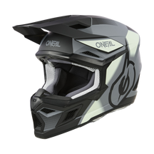 Der O'NEAL 3SRS Helm VISION ist ein schwarz-grauer Motocross-Helm mit elegantem Design. Auf der Vorderseite und an den Seiten ist die Marke „O'Neal“ zusammen mit einer großen Grafik deutlich zu erkennen. Die Innenseite ist für Komfort und Schutz gepolstert.