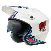Der O'NEAL VOLT Helm MN1 ist ein weißer Motocross-Helm mit integriertem Visier und aerodynamischem Design. Er verfügt über blaue, rote und schwarze Akzente sowie das O'NEAL-Logo an der Seite. Dieser Helm verfügt außerdem über ein leicht getöntes Visier und eine graue Innenpolsterung für zusätzlichen Komfort.
