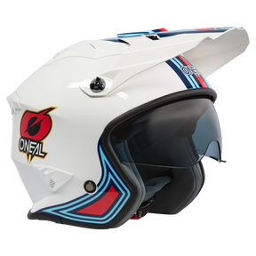 Der O'NEAL VOLT Helm MN1 ist ein weißer Motorradhelm von O'NEAL mit transparentem Visier und aerodynamischem Design. Er zeigt rote, blaue und schwarze Grafiken mit einem eckigen Muster und einem stilisierten „ONEAL“-Logo an der Seite. Dieser Helm verfügt außerdem über Belüftungspunkte und ein bequemes Innenfutter für mehr Komfort.