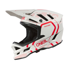 Der O'NEAL BLADE Polyacrylite Helm STRIKE ist ein weiß-roter O'Neal-Motocrosshelm mit eckigen Belüftungsöffnungen, einem Schirmvisier und dem Slogan „ENJOY RIDE“ auf der Oberseite. Das Design zeigt ein auffälliges Muster mit roten Linien und Punkten und bietet mit seinem schwarzen Innenfutter und Kinnschutz sowohl Funktion als auch Komfort.