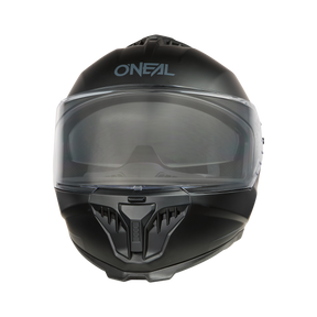 Der O'NEAL CHALLENGER Helm SOLID, ein eleganter schwarzer Integralhelm, trägt das „O'NEAL“-Branding auf der Stirn. Er verfügt über ein klares Visier und einen belüfteten Kinnschutz und hebt sich mit seinem modernen Design vom schwarzen Hintergrund ab.
