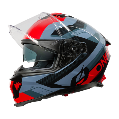 El Casco O'NEAL Challenger EXO presenta un llamativo diseño geométrico en rojo, negro y gris con una visera transparente y la llamativa inscripción "ONE" en el lateral, que destaca de perfil sobre un fondo negro liso: ideal para los aficionados a las motos.
