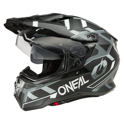 El casco O'NEAL D-SRS SQUARE es un casco de moto negro y gris con un diseño anguloso y geométrico, protección facial transparente, visera, mentonera y aberturas de ventilación, ideal para la conducción todoterreno y de aventura.