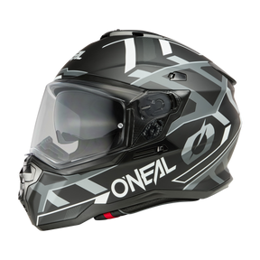 Der O'NEAL D-SRS Helm SQUARE ist ein eleganter, schwarzer Motorradhelm mit komplizierten weißen geometrischen Mustern. Der Helm verfügt über ein klares Visier, markante Belüftungsöffnungen und den seitlich aufgedruckten Markennamen „O'NEAL“. Dieser Schutz bietet ein modernes, technisches Erscheinungsbild, das auf der Straße auffällt.