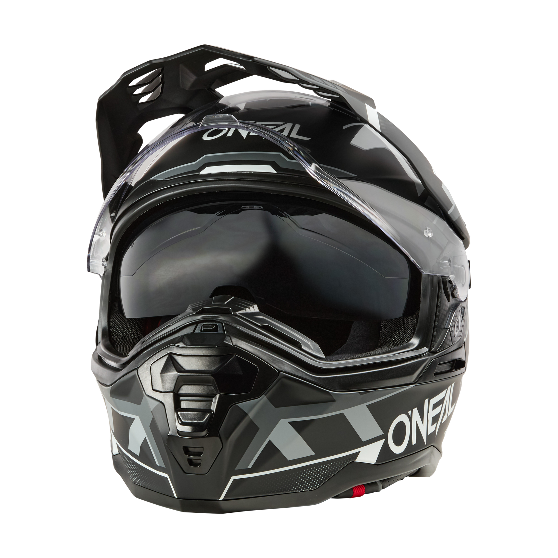 Der O'NEAL D-SRS Helm SQUARE ist ein schwarz-grauer Motorradhelm mit klarem Visier und kantigen, geometrischen Motiven, die auf der Vorderseite vor einem weißen Hintergrund abgebildet sind.