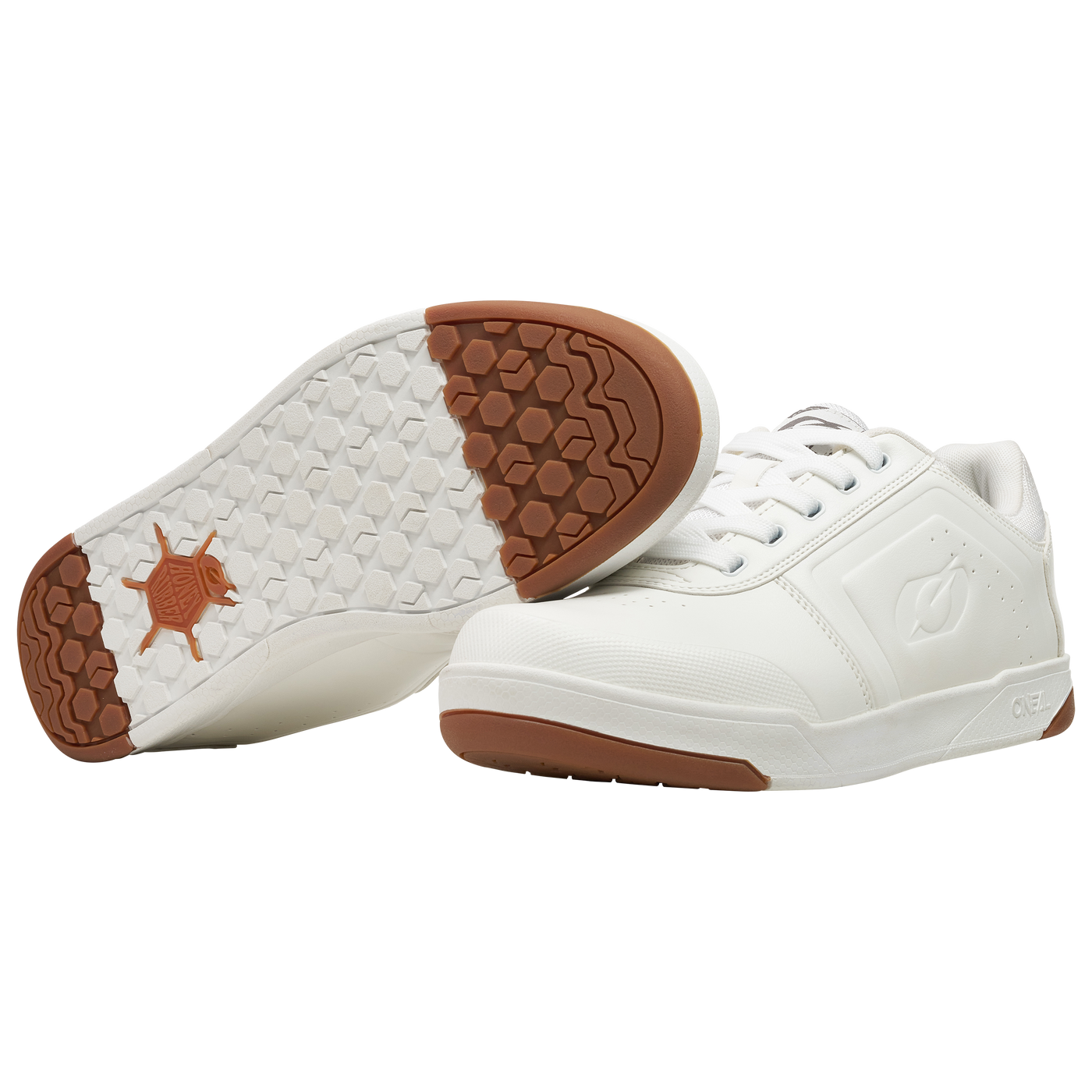 Ein Paar O'NEAL PINNED FLAT Pedal Schuhe von O'NEAL mit weißer Schnürung, gummifarbenen Sohlen mit sechseckigem Profil und dezenter Logoprägung. Ein Schuh steht aufrecht, der andere zeigt seine Sohle.