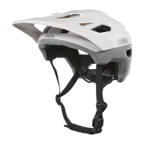 Der O'NEAL TRAILFINDER EVO Helm SOLID in Weiß/Grau verfügt über ein Visier, verstellbare schwarze Riemen und Belüftungsschlitze. Ideal für Trailriding-Enthusiasten. Sein schlankes Design ist mit dem Quin Smart Safety Sensor für verbesserten Schutz kompatibel.