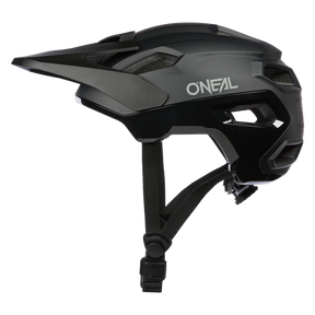 Ein schwarzer O'NEAL TRAILFINDER EVO Helm SOLID mit Visier, seitlichen Belüftungsöffnungen und verstellbaren Kinnriemen ist von der Seite vor einem weißen Hintergrund abgebildet.