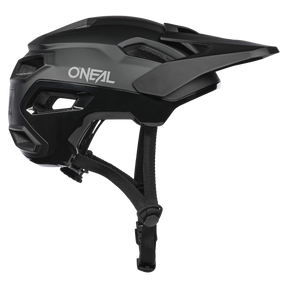 Der O'NEAL TRAILFINDER EVO Helm SOLID in Schwarz und Grau verfügt über ein Visier, mehrere Belüftungsöffnungen, einen verstellbaren Kinnriemen und das O'NEAL-Logo an der Seite – perfekt für Trailriding-Enthusiasten.