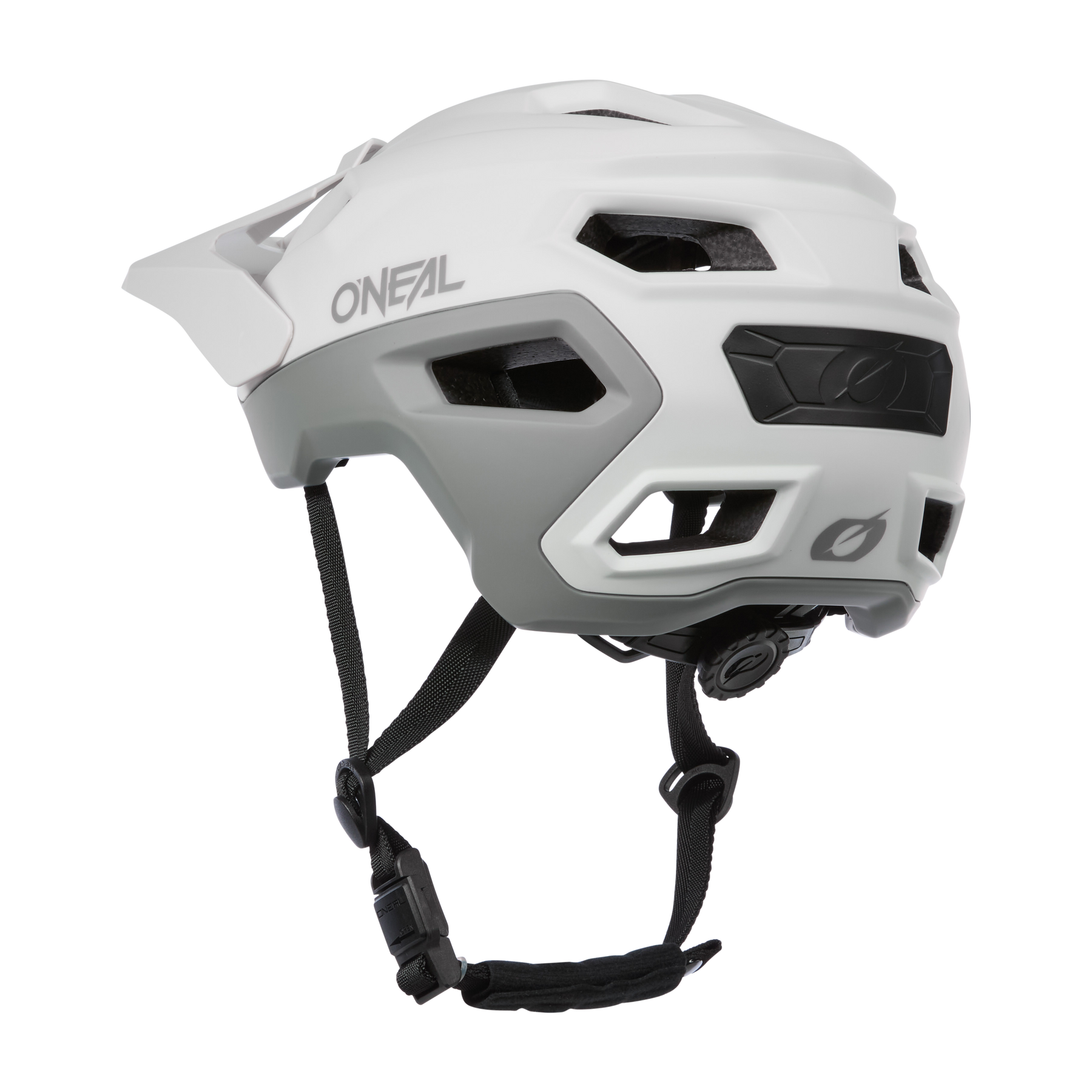 Der O'NEAL TRAILFINDER EVO Solid Quin Bundle ist ein weißer Fahrradhelm mit schwarzen Riemen und mehreren Belüftungsöffnungen. Er verfügt über eine leichte Inmold-Technologie. Er ist von der Seite und etwas tiefer auf einem einfarbigen Hintergrund abgebildet.