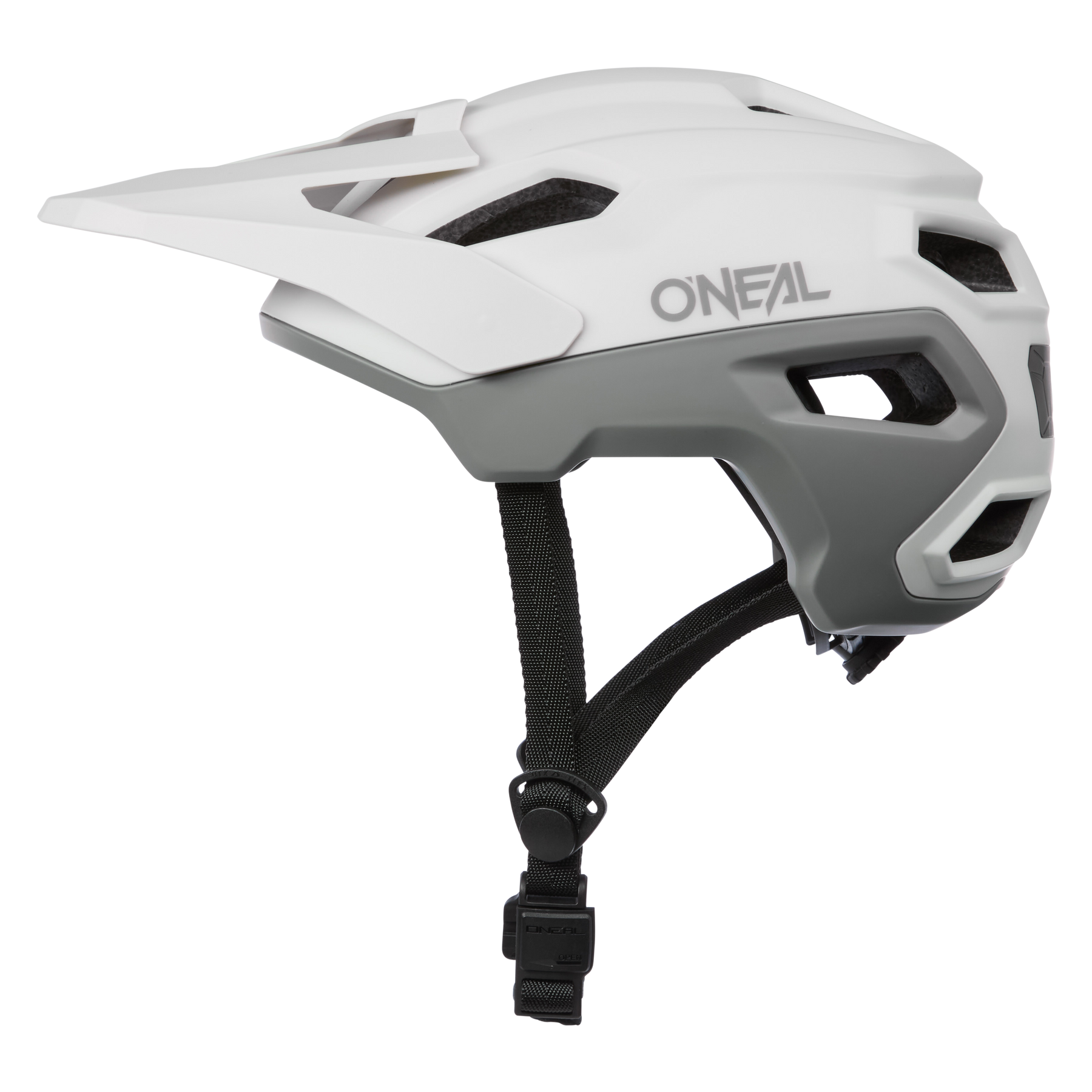 Ein weiß-grauer O'NEAL TRAILFINDER EVO Helm SOLID mit Visier und schwarzen verstellbaren Kinnriemen, in der Profilansicht auf transparentem Hintergrund dargestellt.