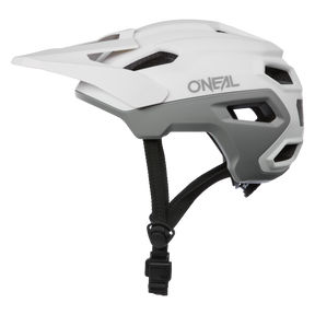 Ein weiß-grauer O'NEAL TRAILFINDER EVO Helm SOLID mit Visier und schwarzen verstellbaren Kinnriemen, in der Profilansicht auf transparentem Hintergrund dargestellt.