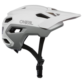 Ein weiß-grauer O'NEAL TRAILFINDER EVO Solid Quin Bundle Fahrradhelm mit Inmold-Technologie, schwarzem verstellbarem Kinnriemen und Visier, von der Seite abgebildet.