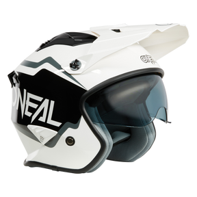 Ein weißer O'NEAL VOLT Helm CORP Motorradhelm mit schwarzen und grauen Akzenten, auf dessen Seite der Markenname O'NEAL deutlich zu sehen ist. Dieses Modell verfügt über ein integriertes getöntes Visier und einen Schirm an der Vorderseite. Das Innenfutter ist hellgrau und sorgt für Komfort und Sicherheit.