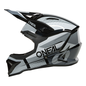 Der O'NEAL 1SRS Helmet RC ist ein schwarzer, weißer und grauer Motocross-Helm mit Visier, Belüftungsöffnungen, einem auffälligen "O'NEAL"-Branding an der Seite und einem modernen Design mit kantigen Linien und geometrischen Mustern.