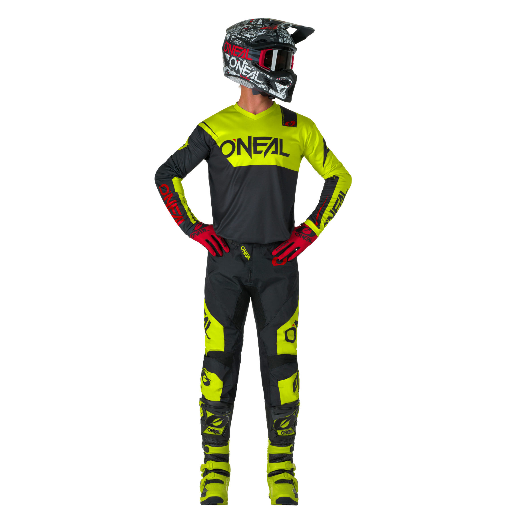 Eine Person steht mit den Händen in den Hüften und blickt zur Seite. Sie trägt O'NEAL ELEMENT Pants RACEWEAR in Schwarz und Neongelb, gepaart mit passendem O'NEAL Helm, Handschuhen, Trikot und Stiefeln.