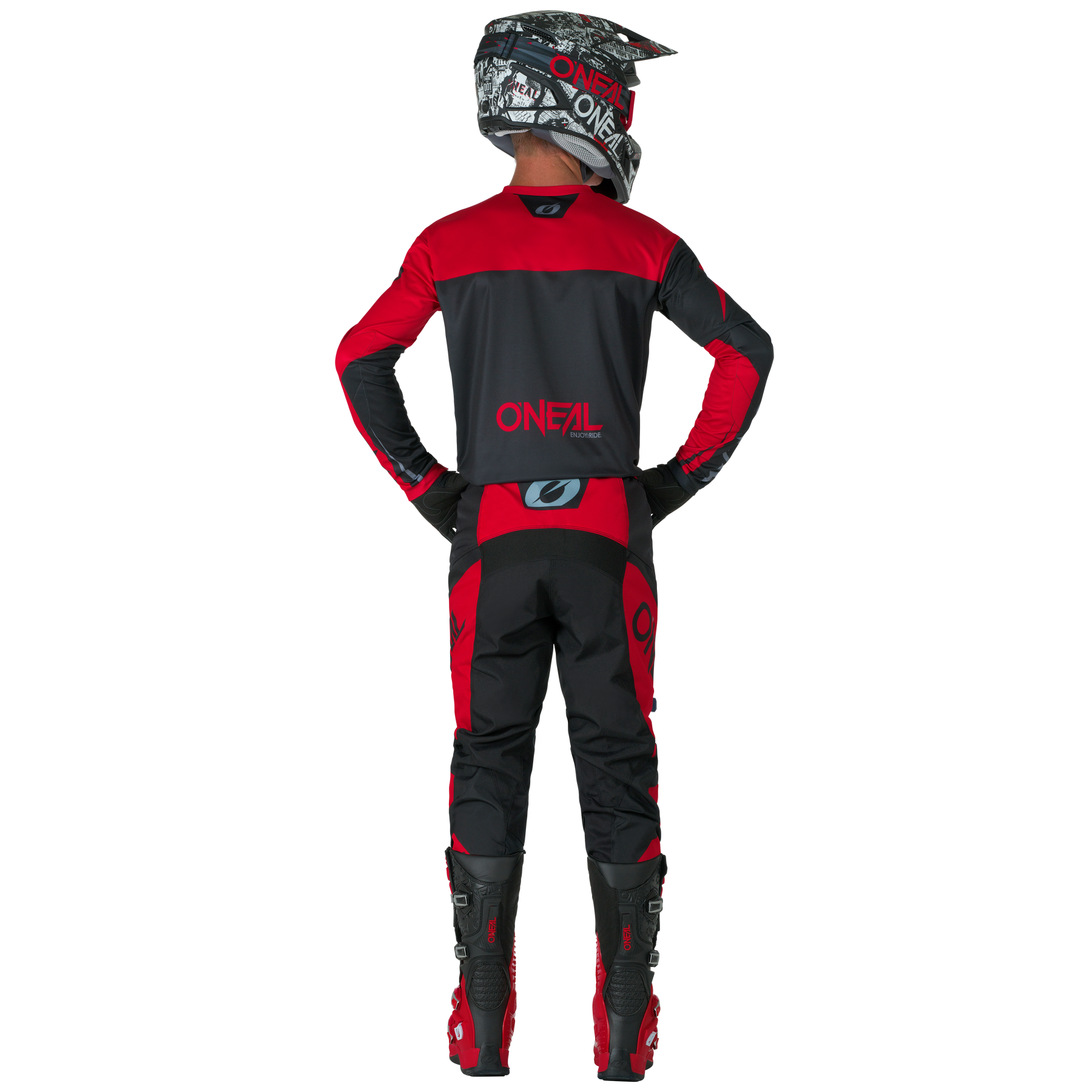 Ein Motocross-Fahrer wird von hinten gezeigt. Er steht mit den Händen in den Hüften und trägt O'NEAL ELEMENT Pants RACEWEAR in Schwarz und Rot sowie passende O'NEAL-Stiefel, Handschuhe und einen Helm.