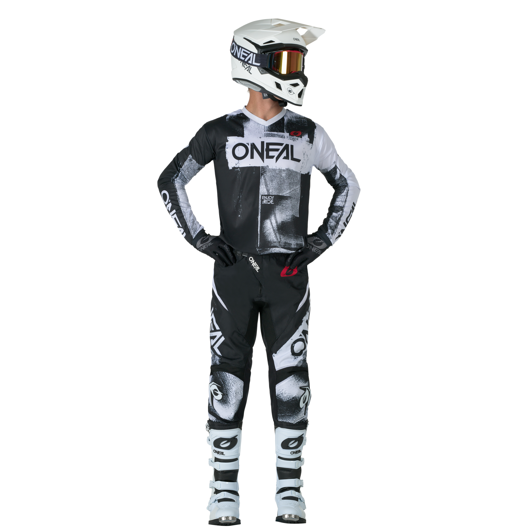 Ein Motocross-Fahrer steht aufrecht und blickt zur Seite. Er trägt den O'NEAL ELEMENT Pants ROLLER sowie einen passenden schwarz-weißen O'NEAL-Helm, eine Schutzbrille, Handschuhe und Stiefel.