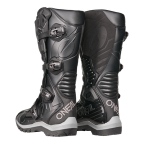 Der O'NEAL RMX Adventure Boot in Schwarz mit Schnallen und strukturierten Details auf weißem Hintergrund ist die ideale Ergänzung für jede Motorsport-Kollektion.