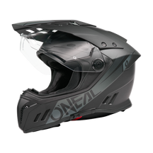Ein Schwarz/Weiß O'NEAL SIERRA RS Helm SOLID mit klarem Visier, aerodynamischen Belüftungsöffnungen, Quin Smart Safety Sensor und fetten seitlichen Schriftzügen wird vor einem schlichten schwarzen Hintergrund dargestellt.