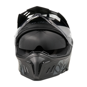 Frontansicht des O'NEAL SIERRA RS Helm SOLID in Schwarz und Grau mit klarem Visier, dunkel getöntem Schild, Belüftungsschlitzen und O'NEAL Branding - kompatibel mit dem Quin Smart Safety Sensor für verbesserten Schutz.